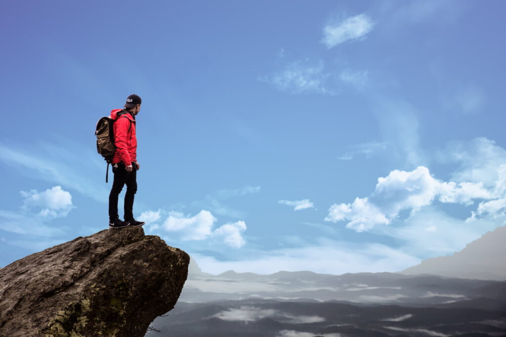 climber looking out from a summit, reflecting on mental and physical achievement after embracing calisthenics and climbing.