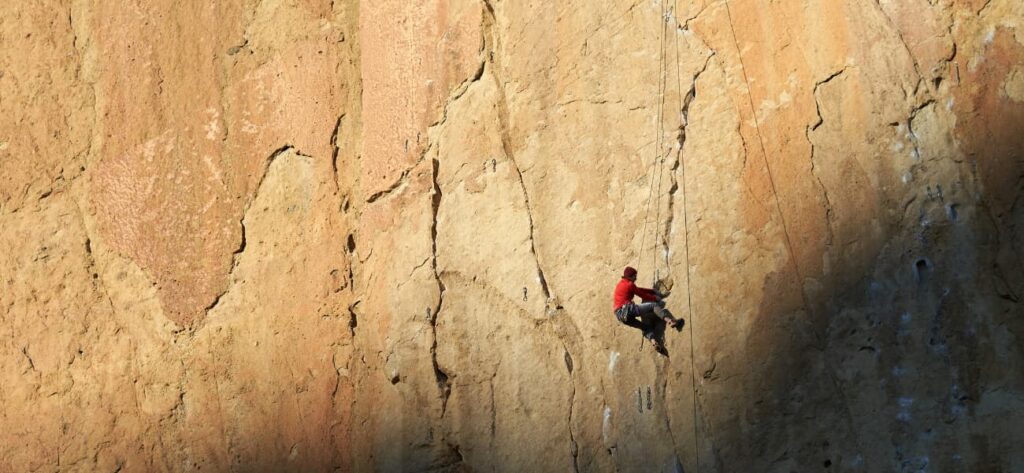 Climber on a cliff about to experience a fear of climbing.